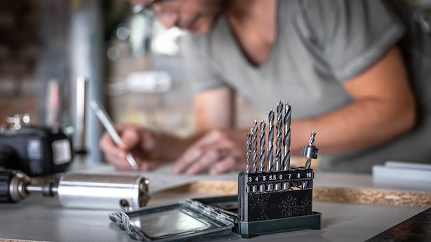 close-up-set-wood-drills-work-table-joiner-workshop_169016-12921