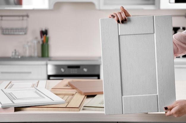 female-hands-holding-sample-wooden-panels-furniture-door_392895-93306