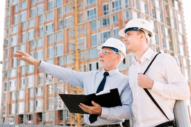 low-angle-old-man-with-helmet-pointing-something_23-2148269324