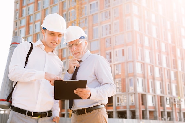 medium-shot-men-with-building-scaffolding_23-2148269317
