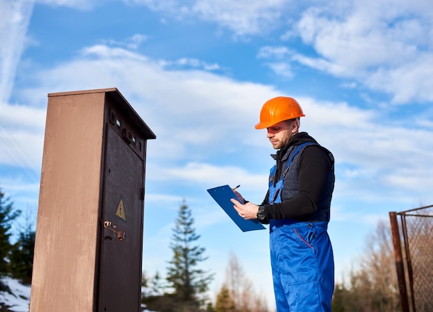 oil-inspector-protective-overalls-orange-helmet-making-notes-transformer_651396-1818