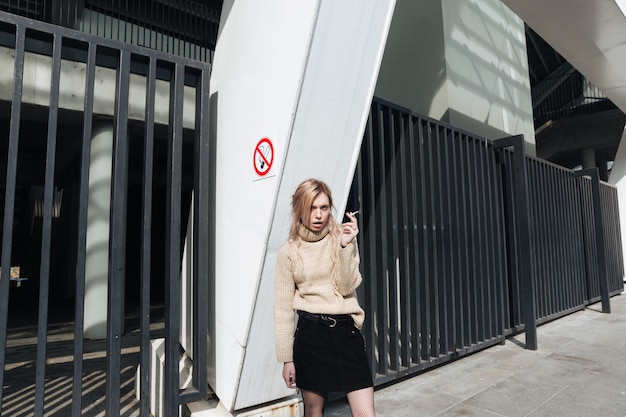 serious-young-blonde-lady-with-cigarette_171337-19403